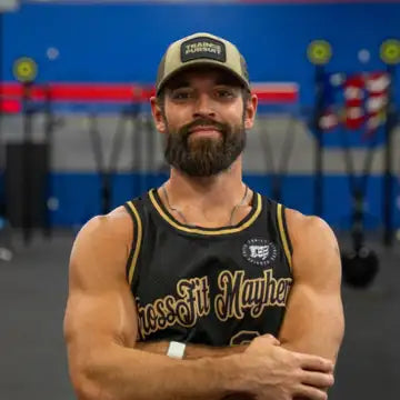 Rich Froning, arms crossed, in a CrossFit gym