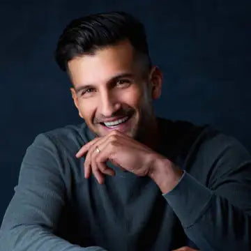 Sahil Bloom smiling, in a gray sweater